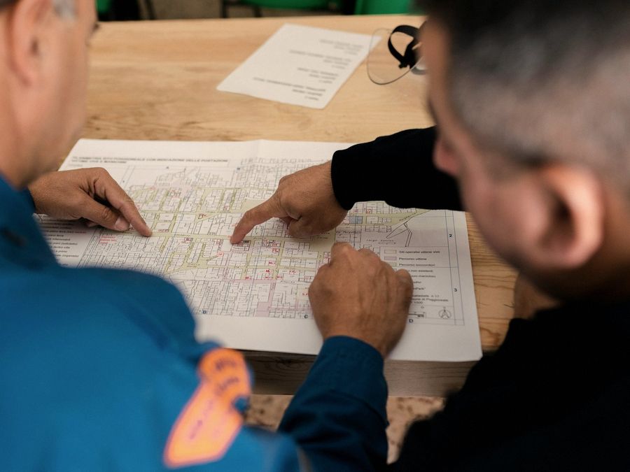 Dos personas revisan planos y registros sobre una mesa de trabajo